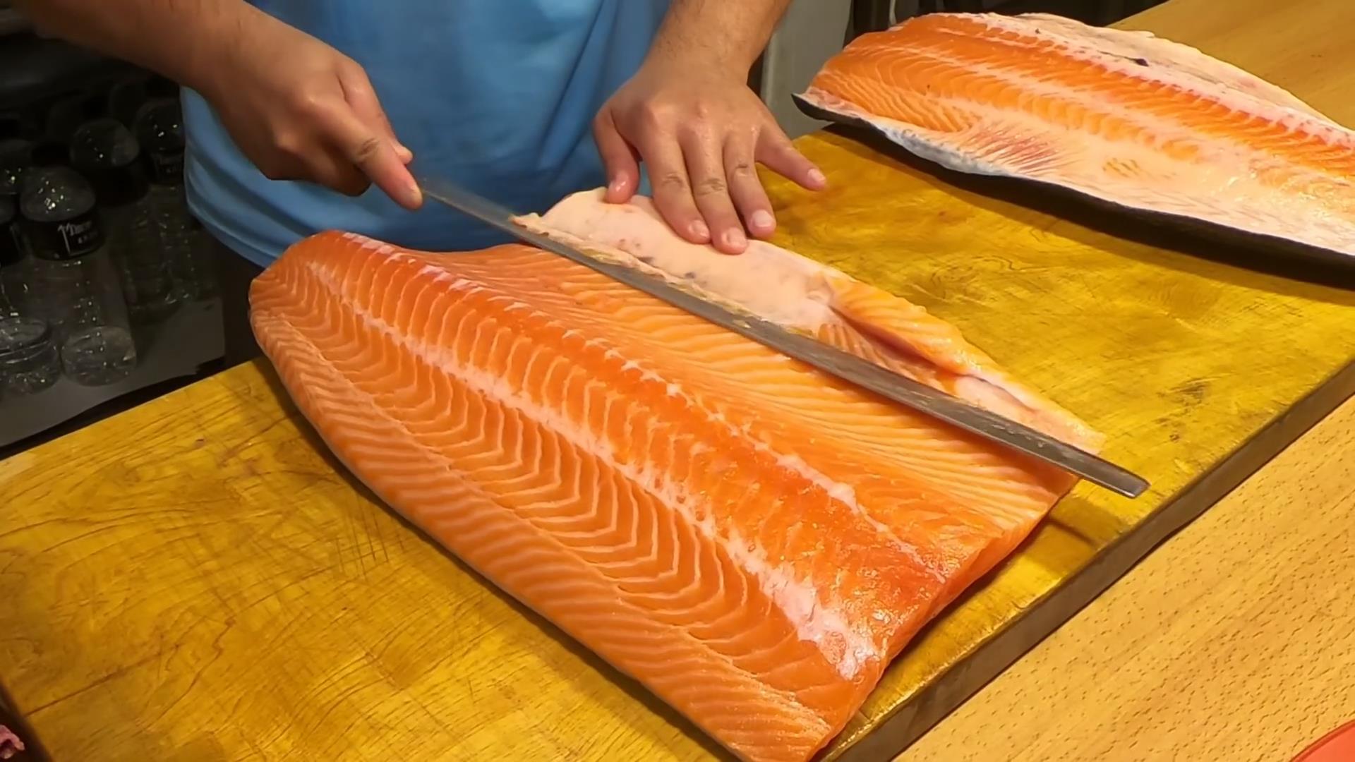 厨师处理整条挪威大西洋鲑鱼,三文鱼快刀分割切段做刺身!