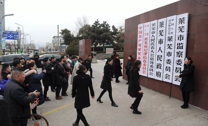 莱芜市撤市设区并入济南市人们来到原莱芜市政府门前拍照留念