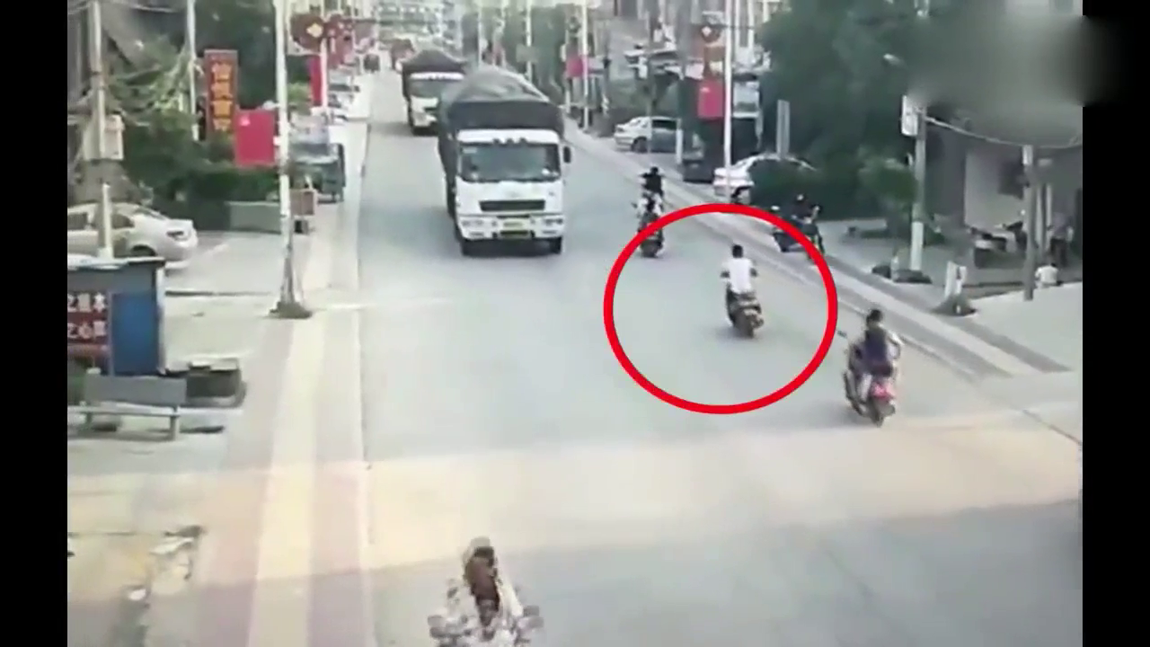 男子骑电动车突然钻入卡车底部