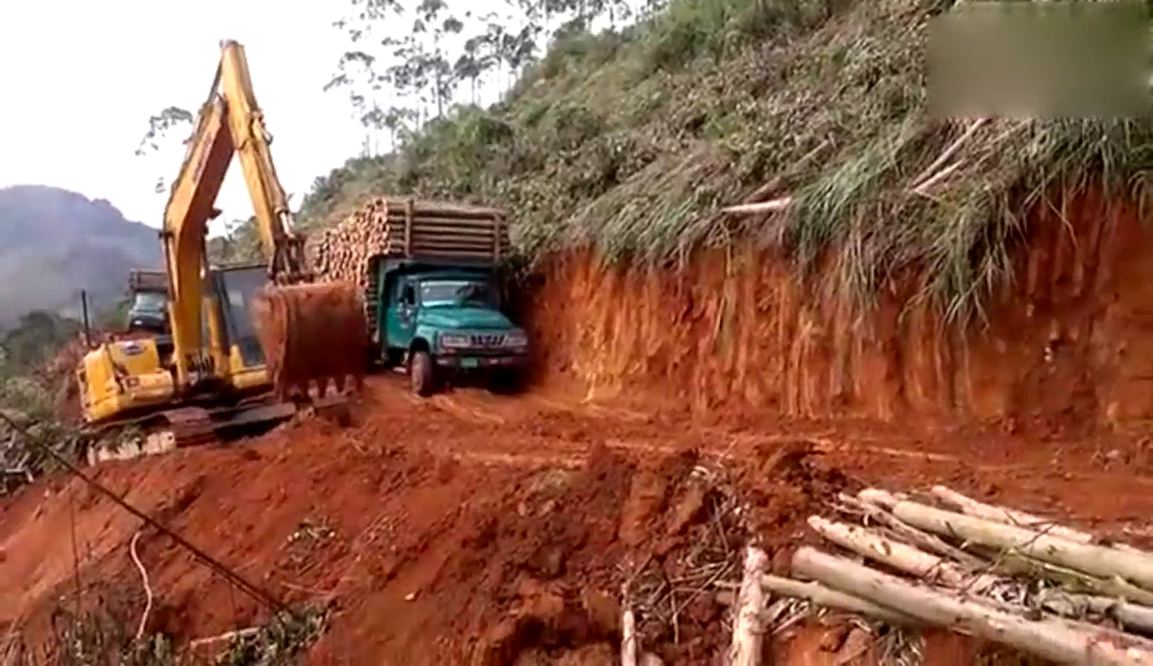 实拍卡车满载木材冒险过山坡土路