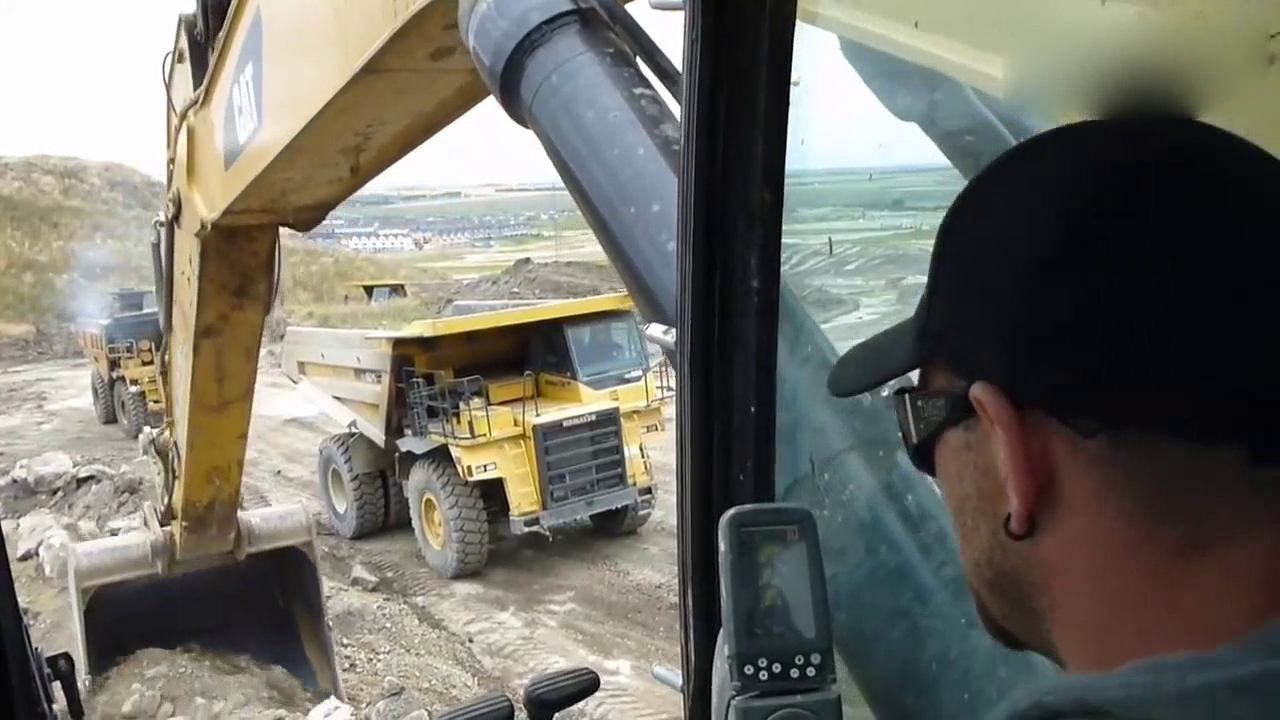 驾驶室实拍：开挖掘机给矿用卡车装料，这个挖斗干活很给力