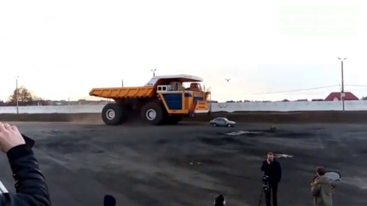 450吨自卸卡车从轿车身上轧过，轿车立马变铁饼！