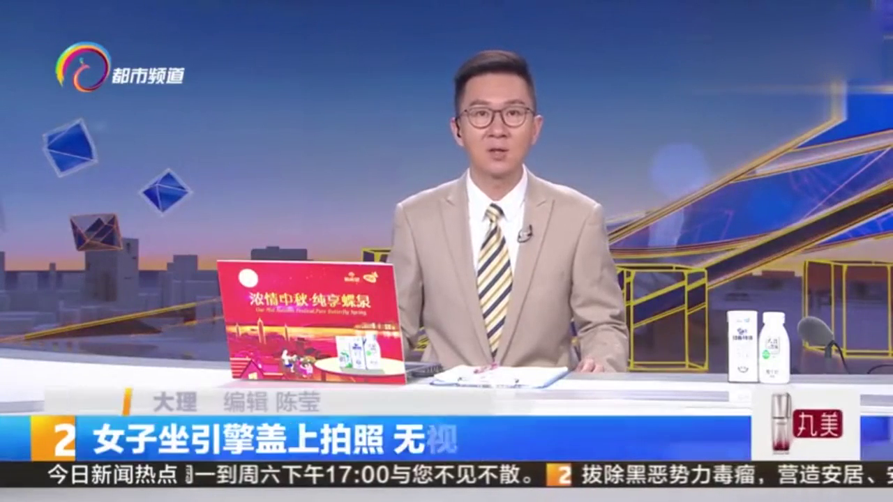 女子坐引擎盖上拍照，无视交通安全，交警已向当事人开出罚单