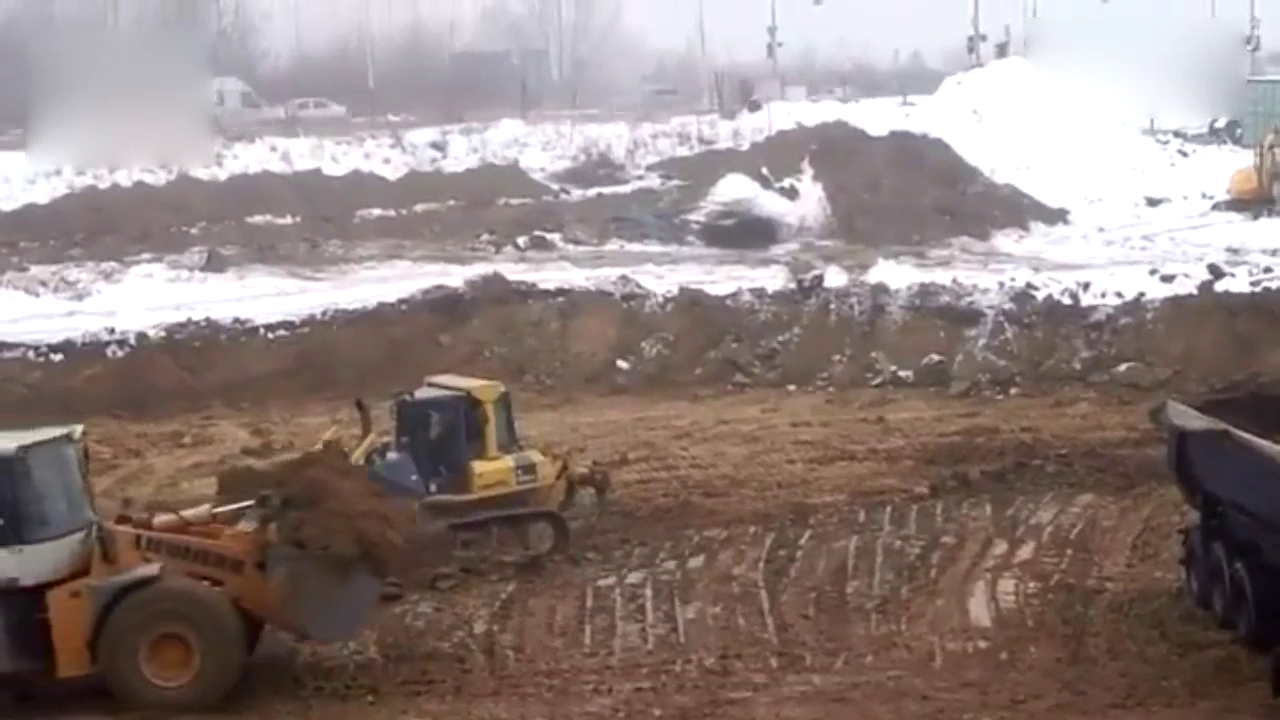 大卡车装完土之后车轮打滑，推土机从后面帮忙推一把！