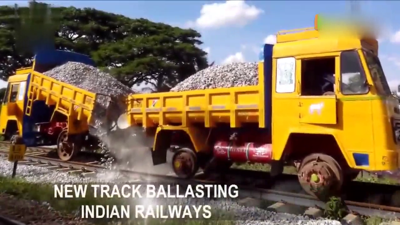 实拍印度工人用卡车装铁轮给火车轨道铺石子