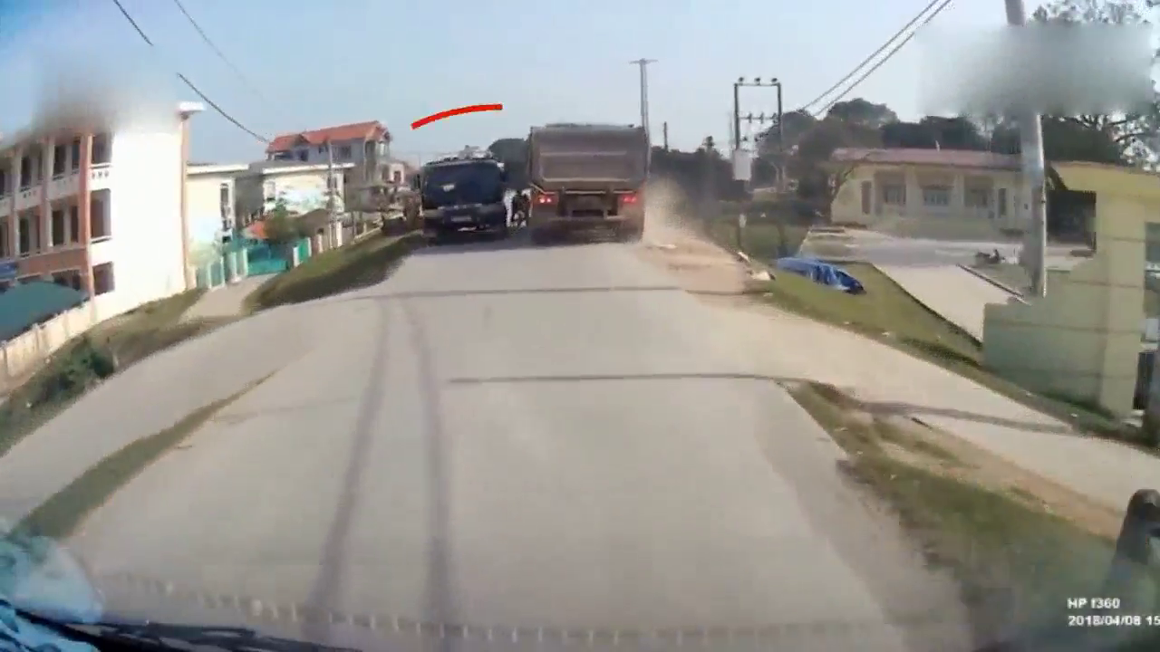 两个孩子在卡车之间穿行，还好司机及时刹车，不然就悲剧了！