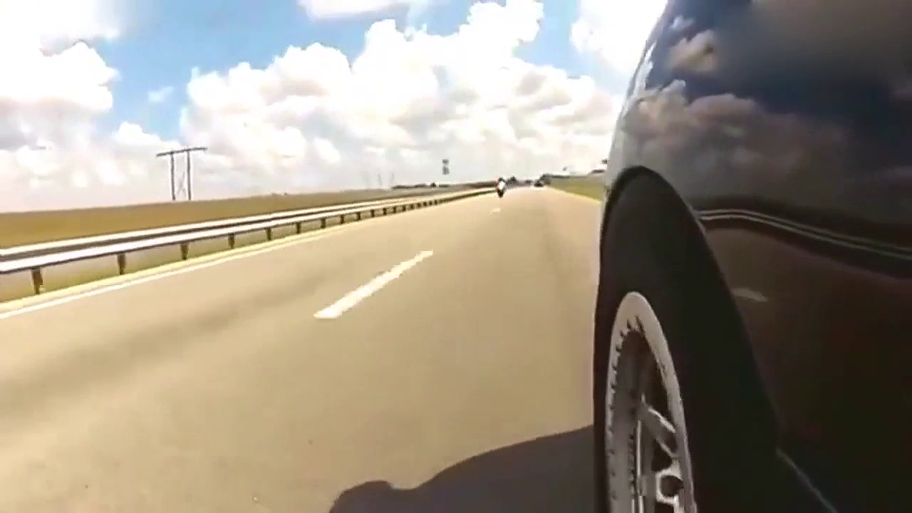 两辆重摩托机车和跑车飙车