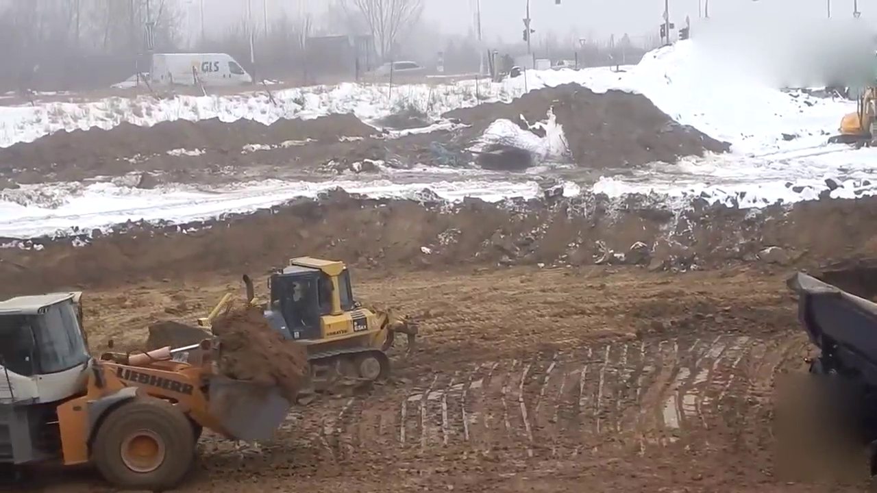 大卡车装完土之后车轮打滑，推土机从后面帮忙推一把