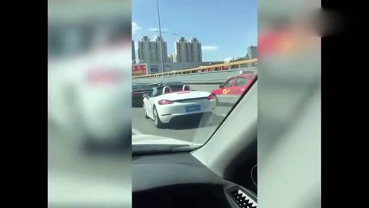 大热天，还开敞篷的跑车，你看这俩人在保时捷里晒得，好黑！