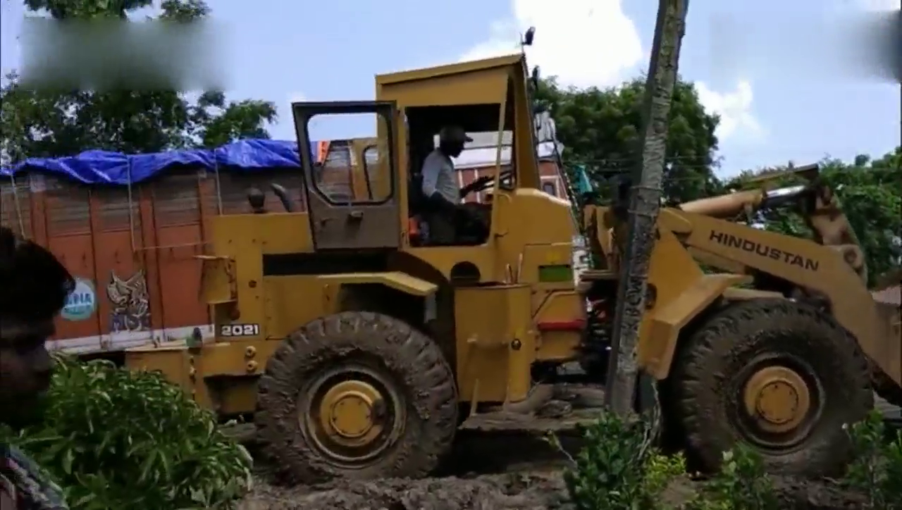 卡车深陷泥中，被轮式装载机推起