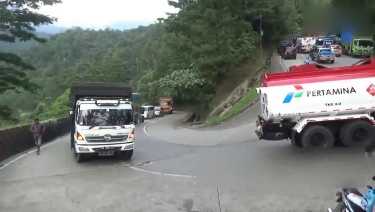 卡车在斜坡弯道上卡住了，两边的路都被塞住了