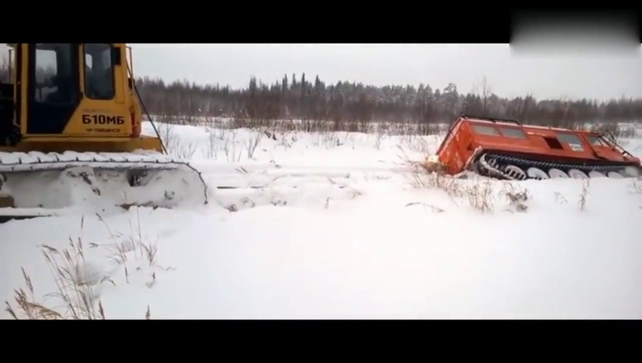 在冰天雪地卡车掉坑中，两台挖掘机来相助