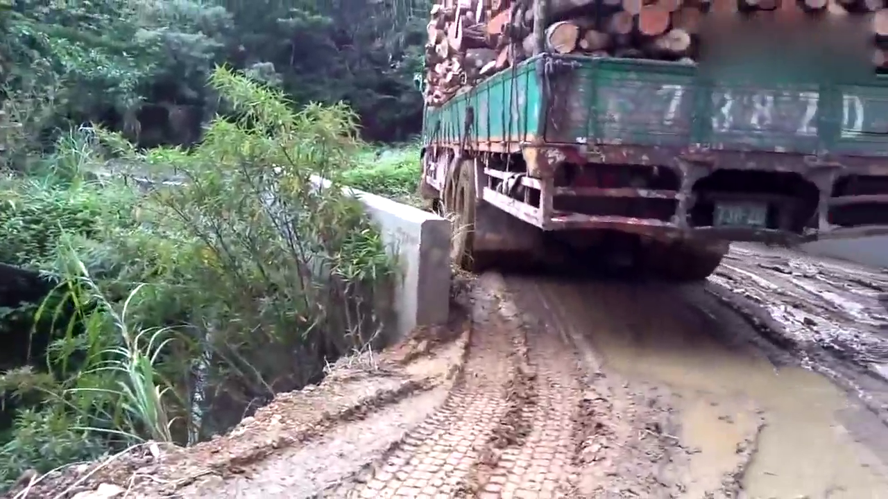 三菱大卡车满载木头走泥路，感觉差点要翻车了