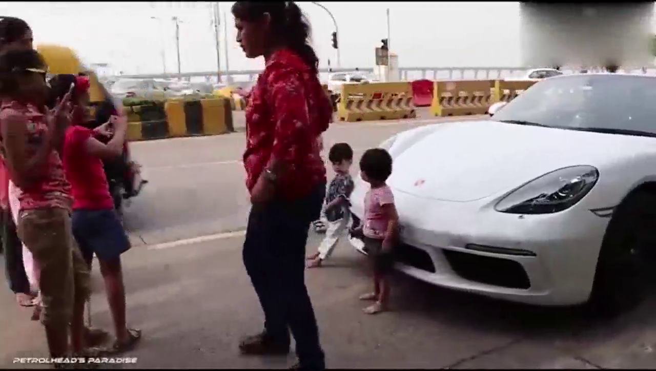 小伙背靠保时捷跑车玩耍！
