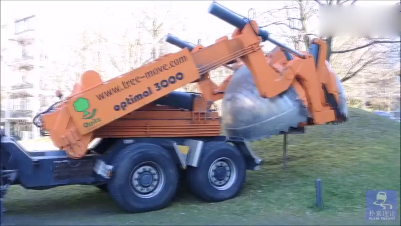 使用太脱拉卡车底盘的工程车，挖断树根把大树抱走