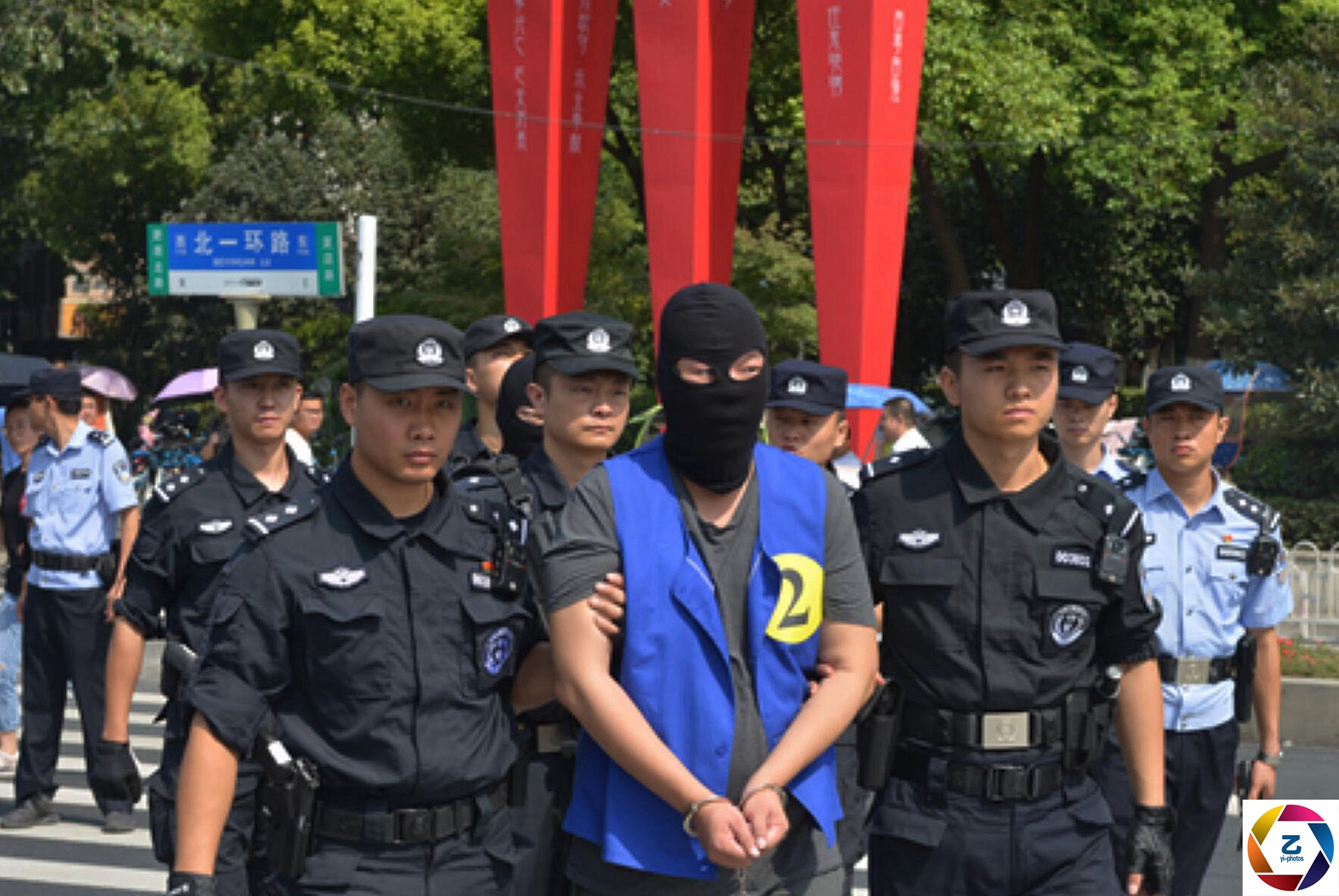 警方押解家族式犯罪团伙指认现场,蒙面人站一排,群众拍手称快