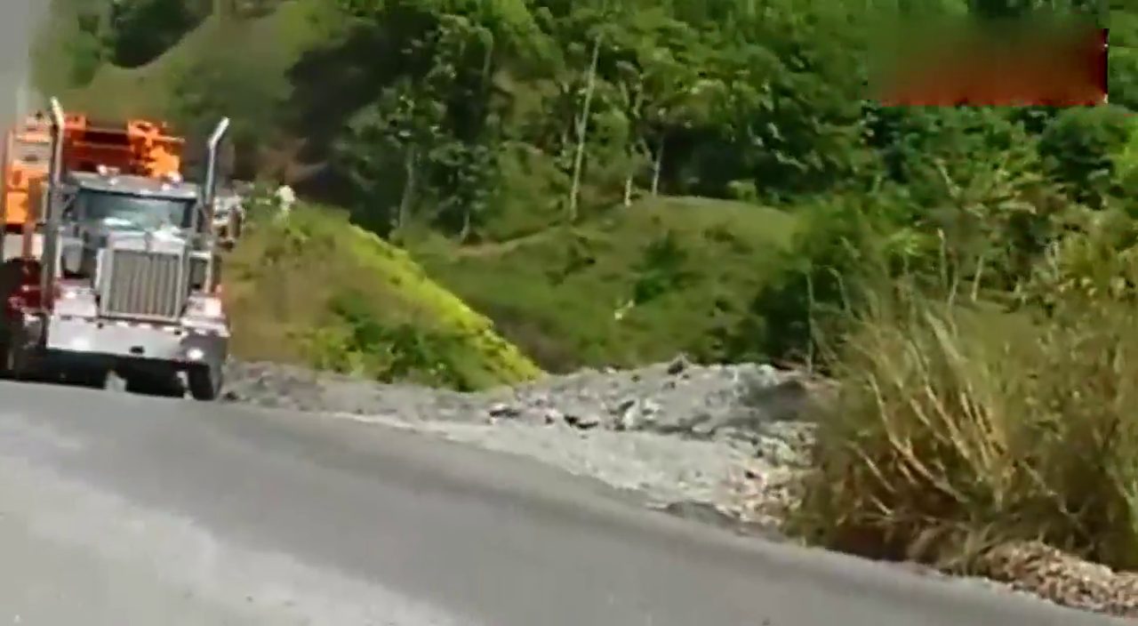 公路上的大卡车拉运大型机械时的场景