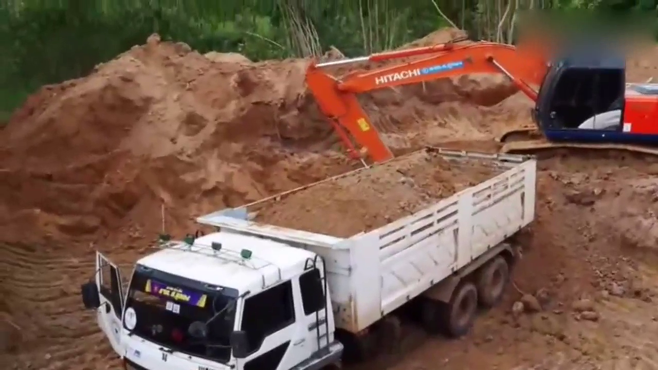 挖掘机给卡车装土，这速度卡车司机坐不住了爬上车顶看看！