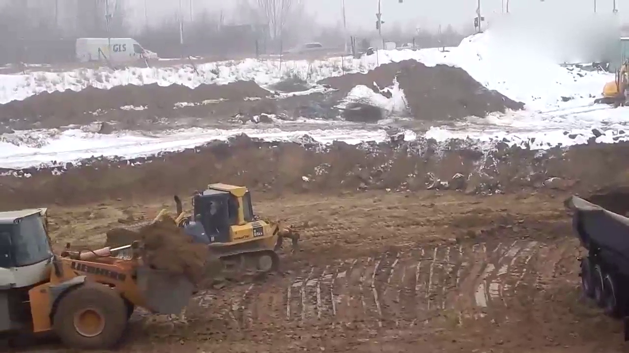 大卡车装完土之后车轮打滑，推土机从后面帮忙推一把