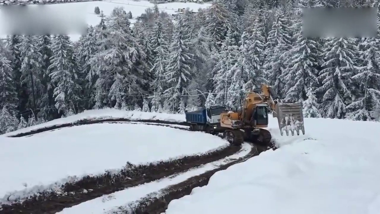 挖掘机在雪地艰难前行 居然还拖着一辆大卡车