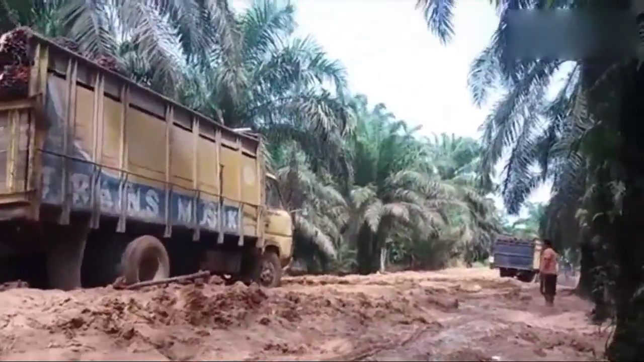 泥泞道路上的卡车，旁边摩托司机笑了