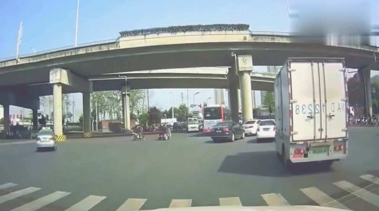 电动车女子疯狂闯红灯，刚躲过了小轿车，却一头撞上了面包车