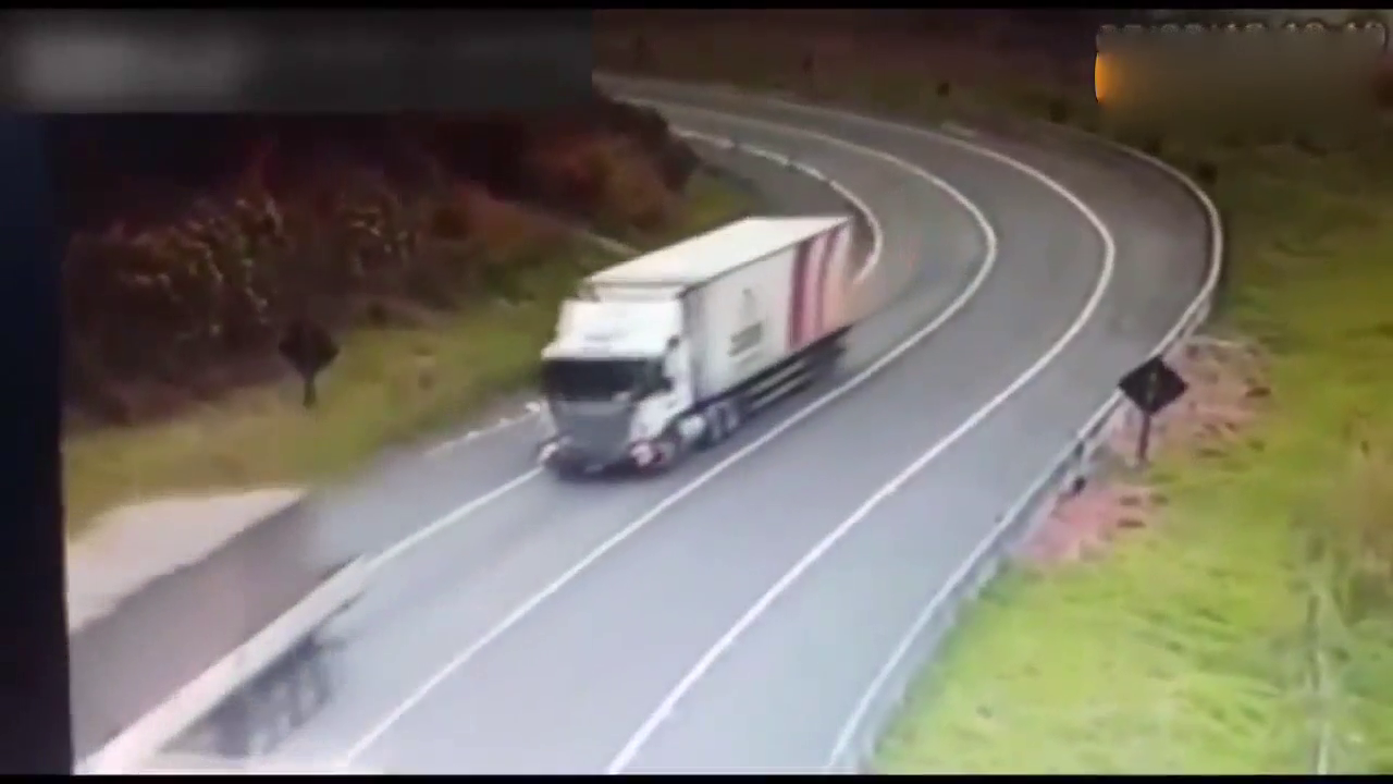 大卡车弯道翻车， 挡风玻璃处司机死里逃生