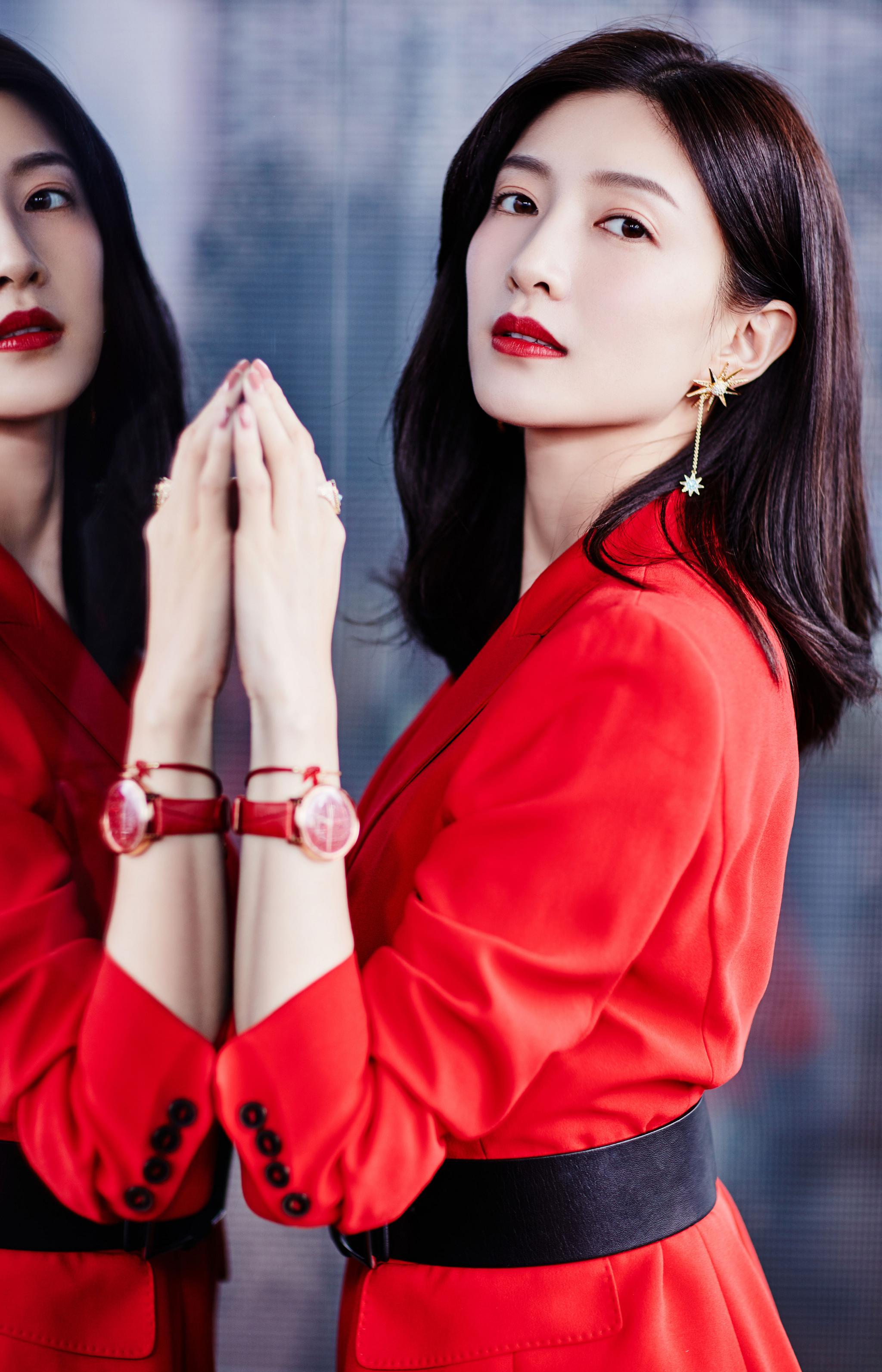 江疏影身穿一款红色短版风衣,时尚靓丽