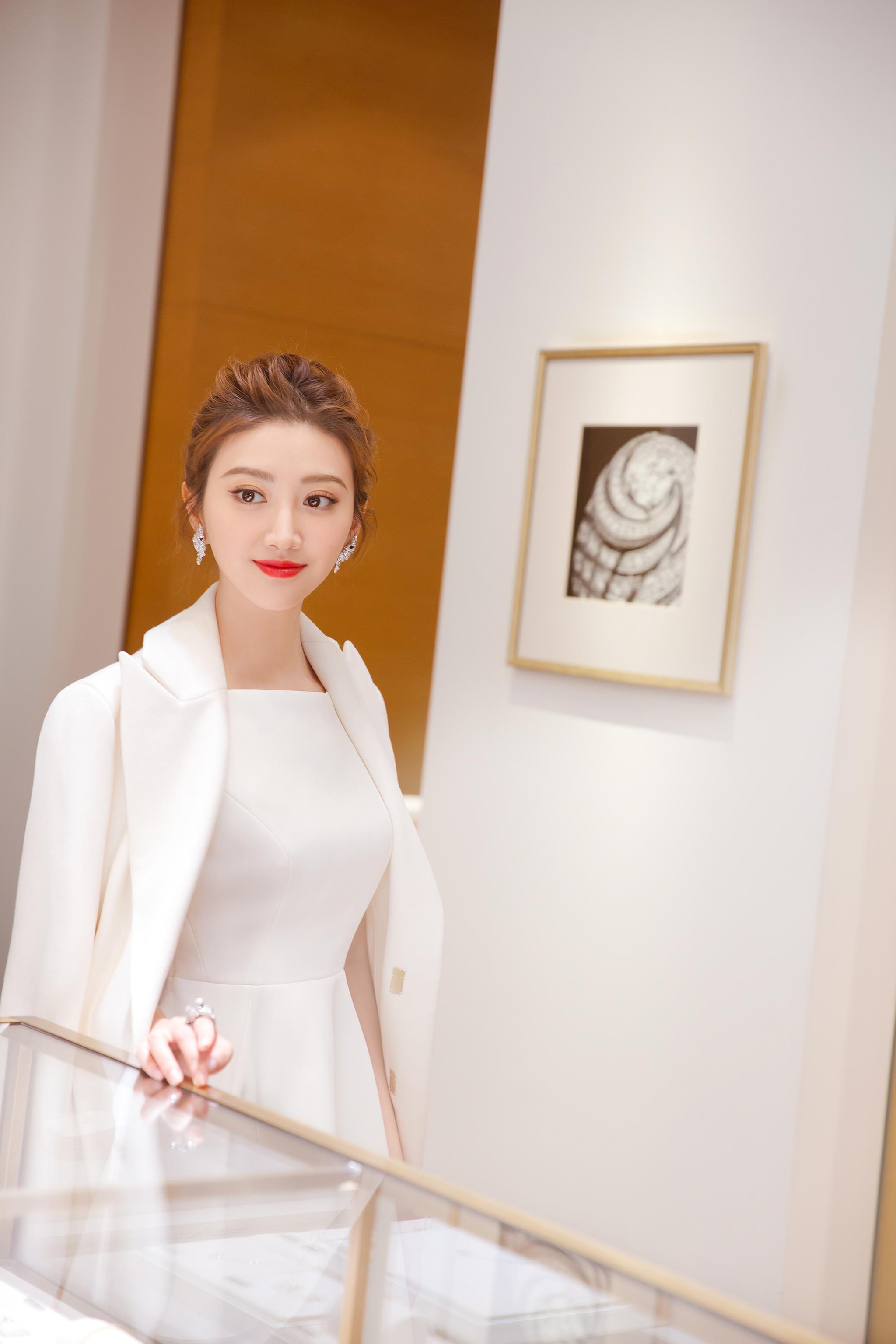 景甜身着白色优雅礼服,外搭白色大衣,性感的烈焰红唇