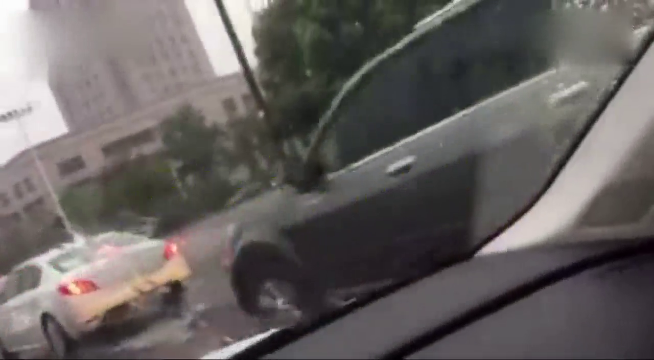 大雨倾盆，男子打雨伞开敞篷跑车