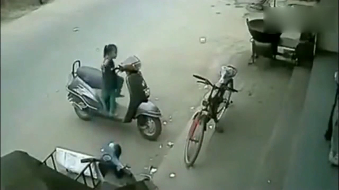 小姑娘在门外摆弄电动车，突然车子发动，监控拍下揪心的画面