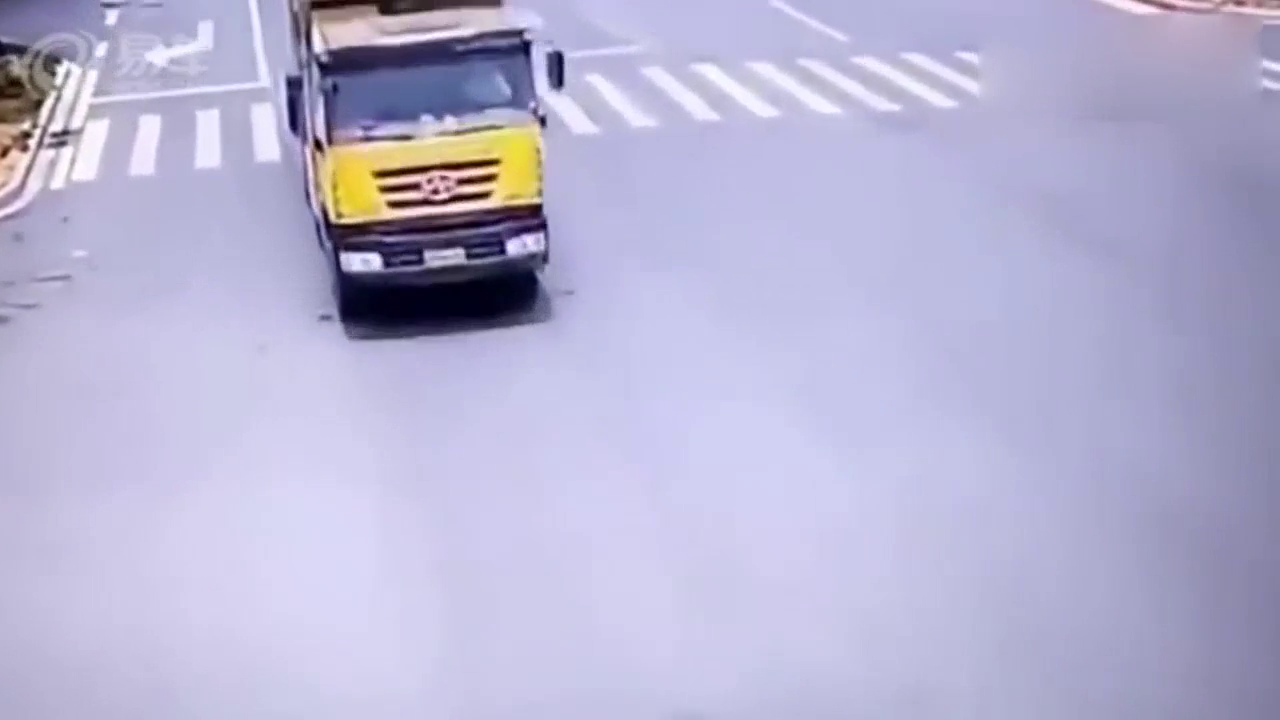 男子骑电瓶车闯红灯，两辆卡车轮下奇迹还生