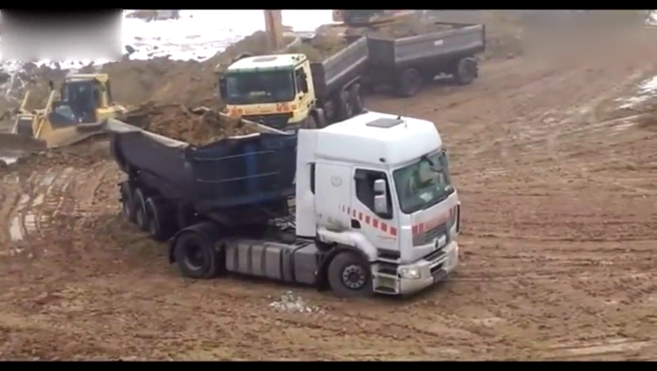 卡车装完土之后车轮打滑，推土机从后面帮忙推一把