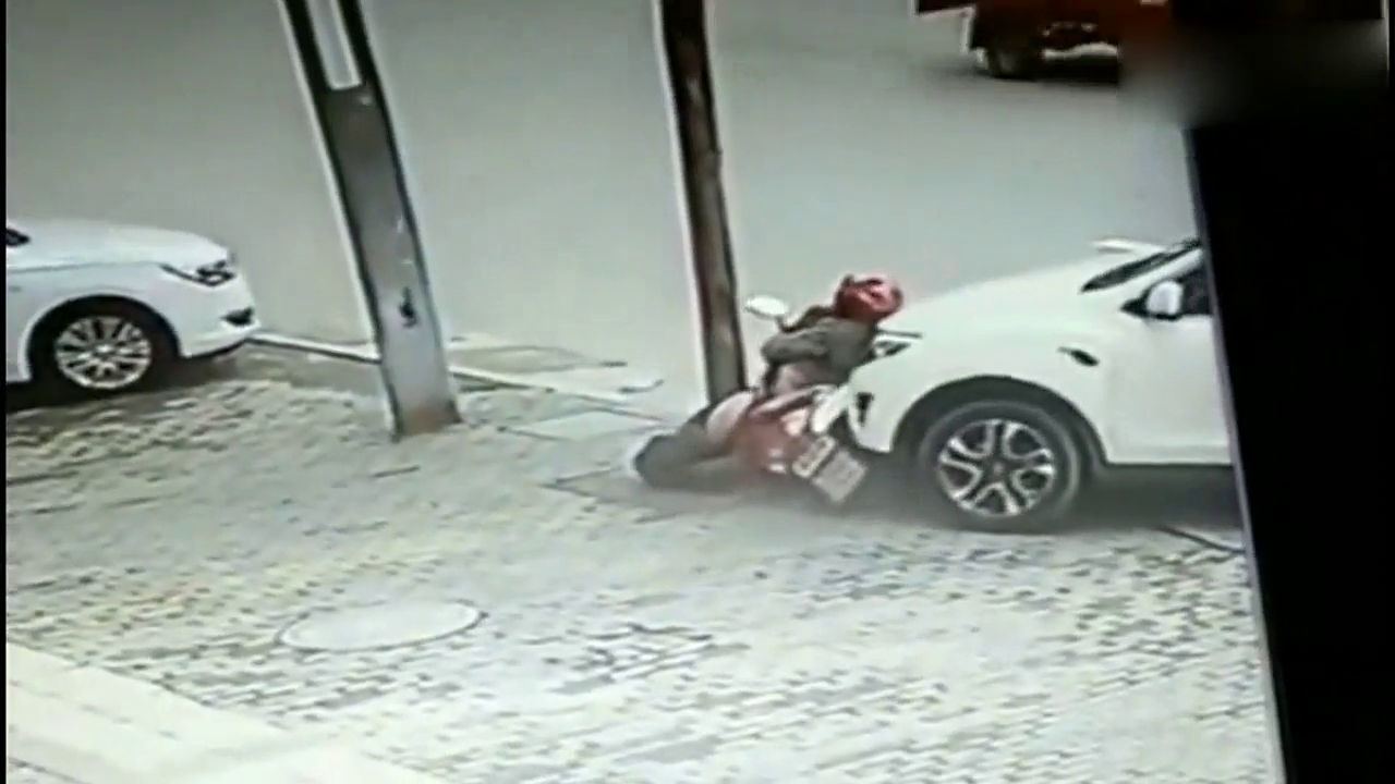 白色轿车失控把骑电动车女子撞上电线杆