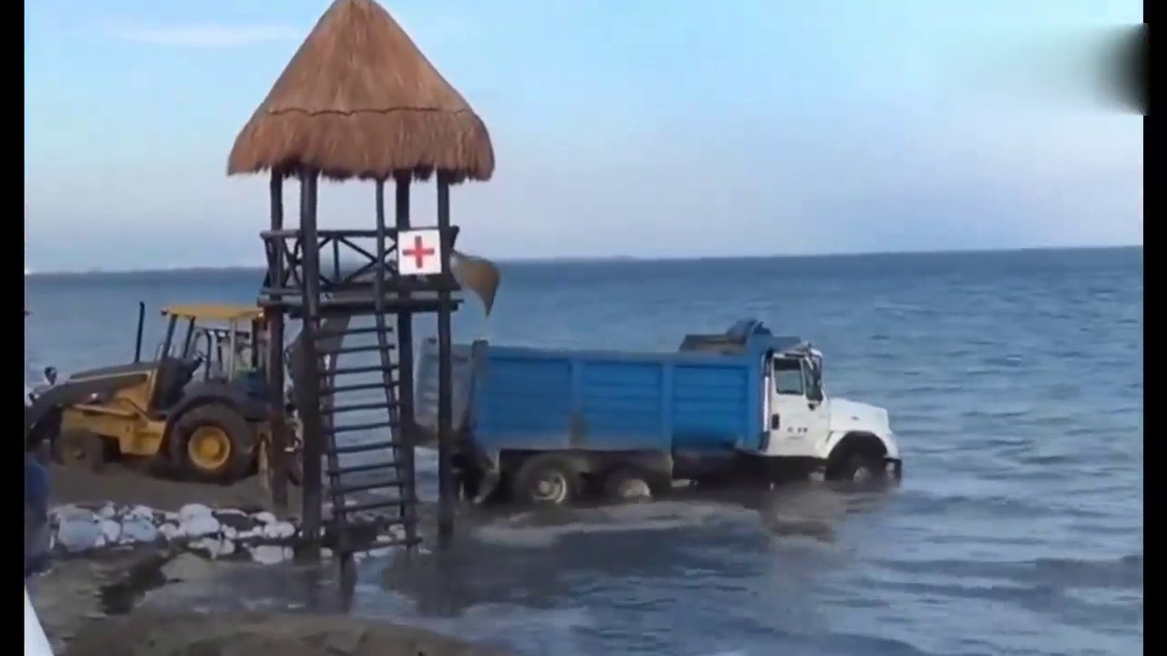 挖掘机救援掉进大海的卡车，没想到卡车把挖机一步步拉向大海
