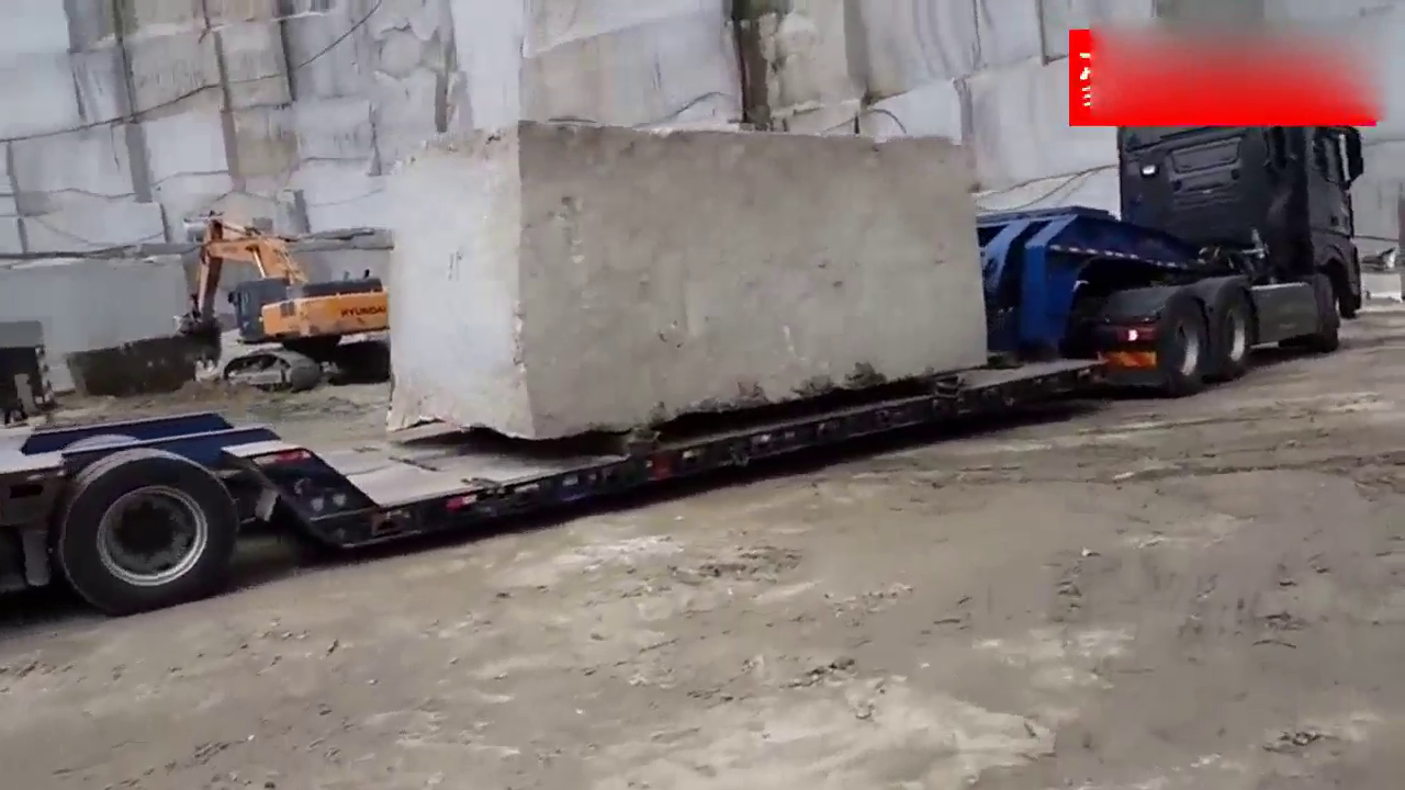 卡车拉着巨石 爬坡的时候铲车在前面拉 后面还需要挖掘机推一把