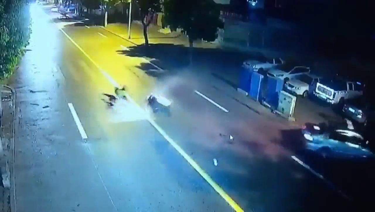 摩托车撞上违章出租车 俩小伙重摔在地