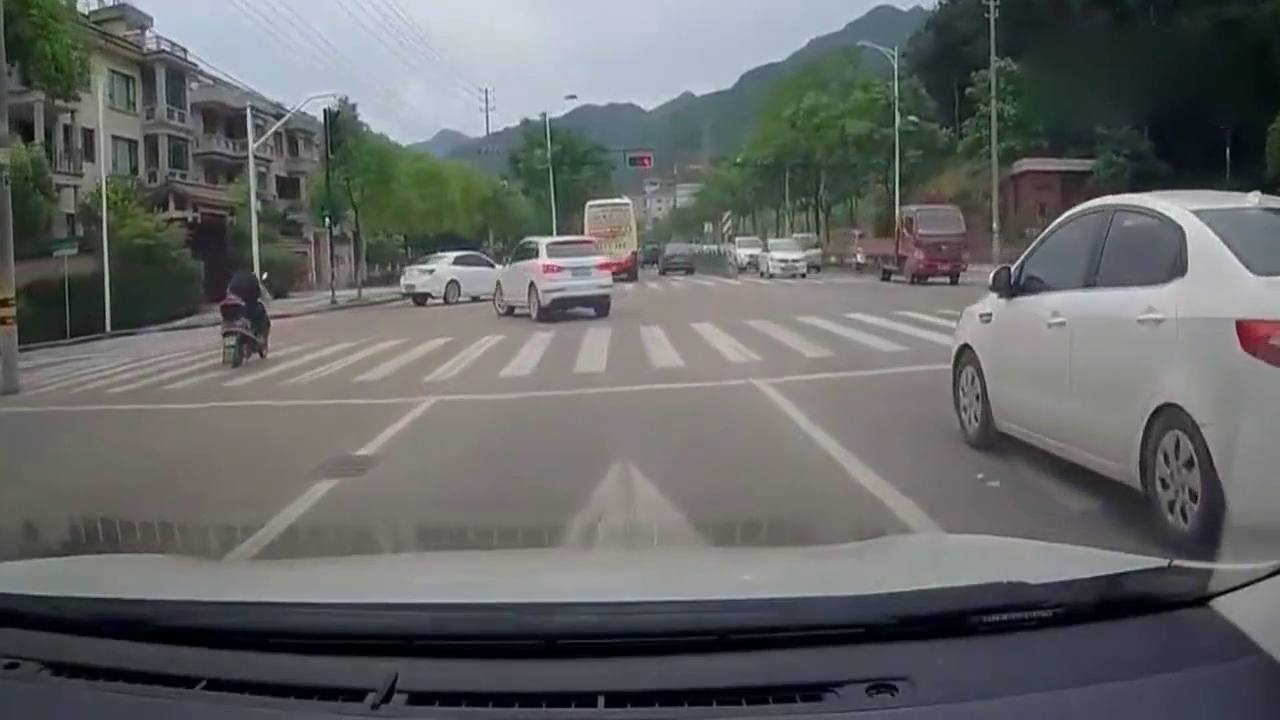 电动车看着红灯往前冲，轿车司机并没有停下，监控拍下这样一幕