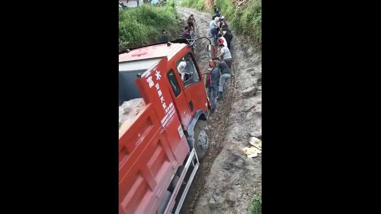 十几个人拉大卡车上坡