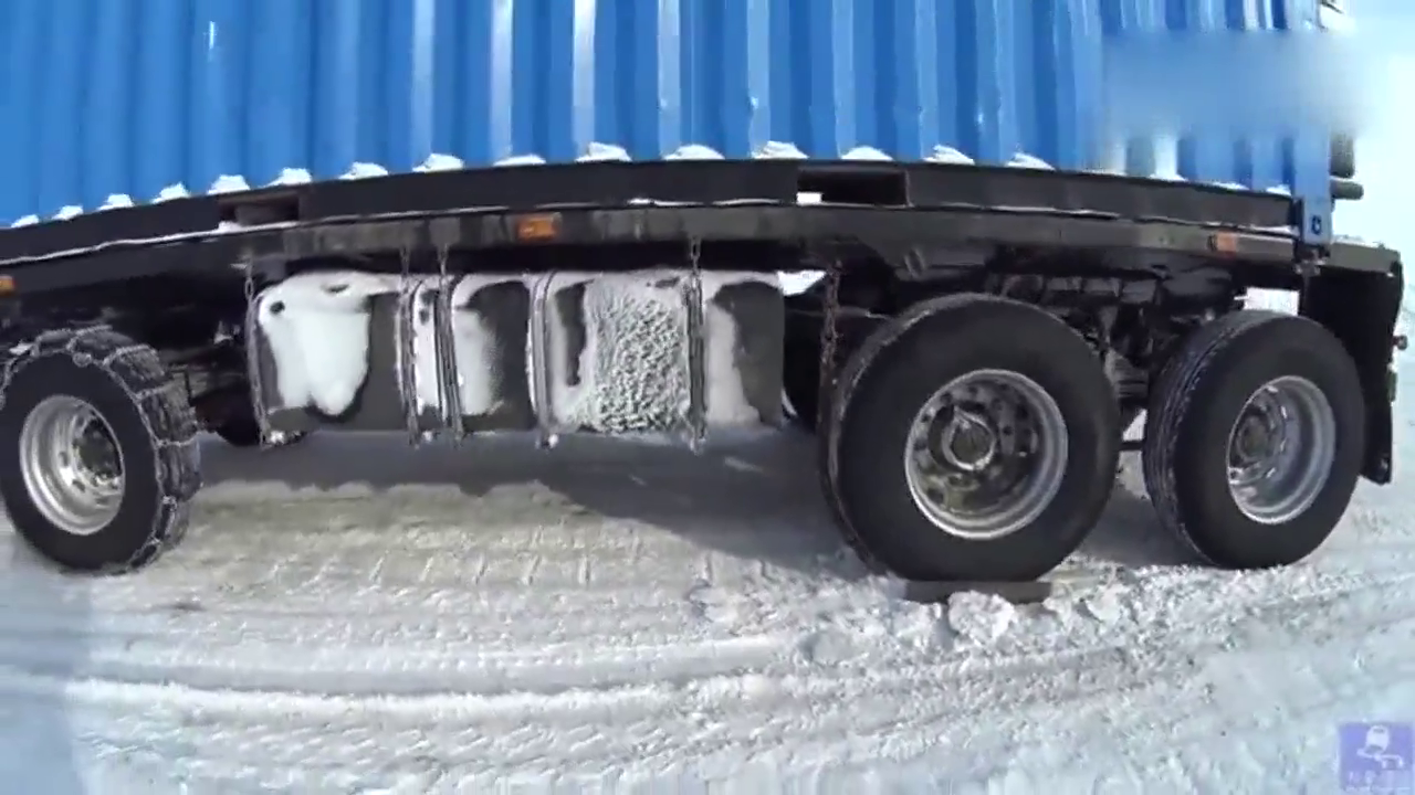 卡车在冰雪路面下长坡，用铁链和钢板锁止车轮