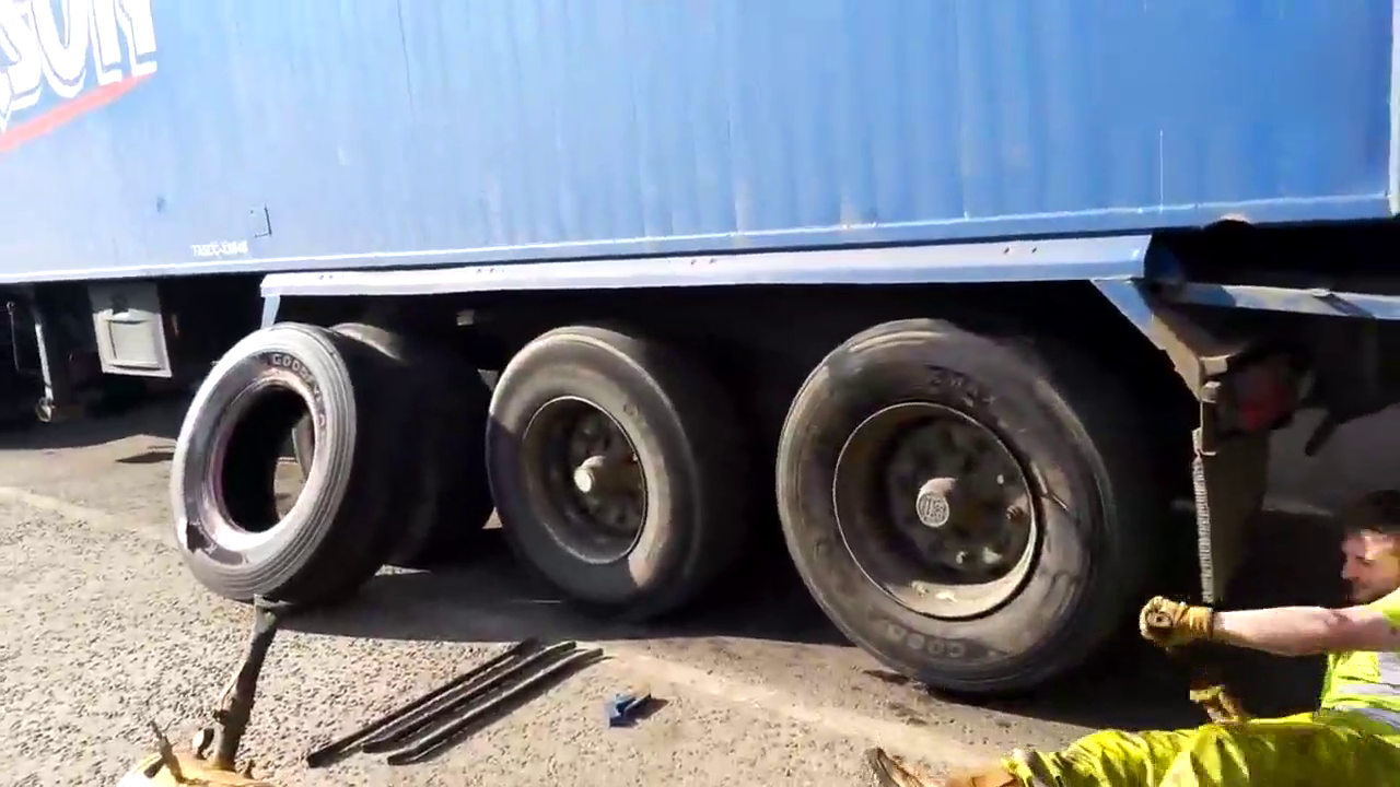 熟练工人快速给卡车更换轮胎