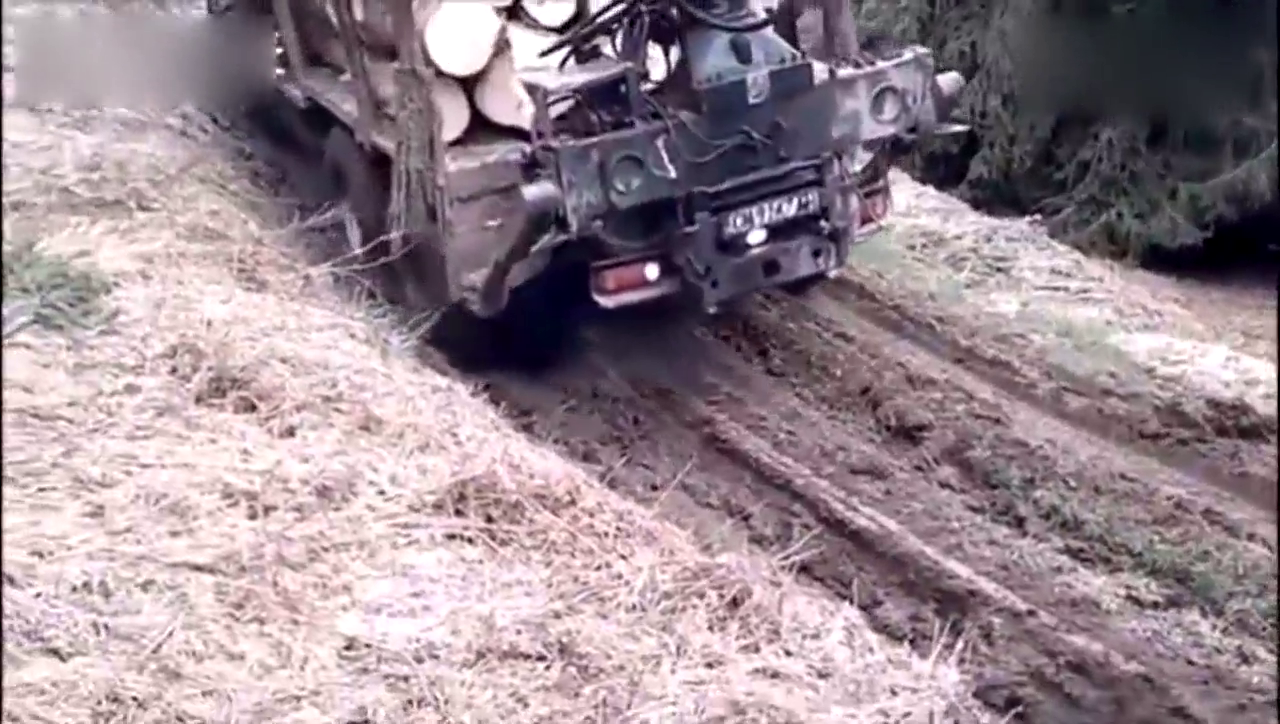 依维柯6X6卡车在泥泞的山路上运输木头