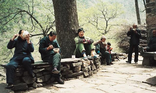1985年农村生活历史老照片:那时候很多农村人很喜欢端着饭在大树底下