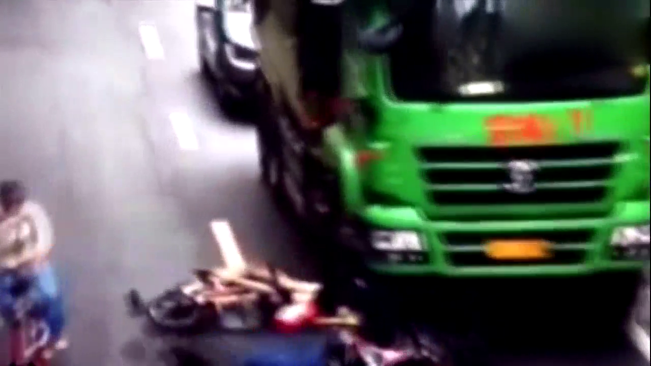 两电动车怒挤，双双摔倒在大货车底下