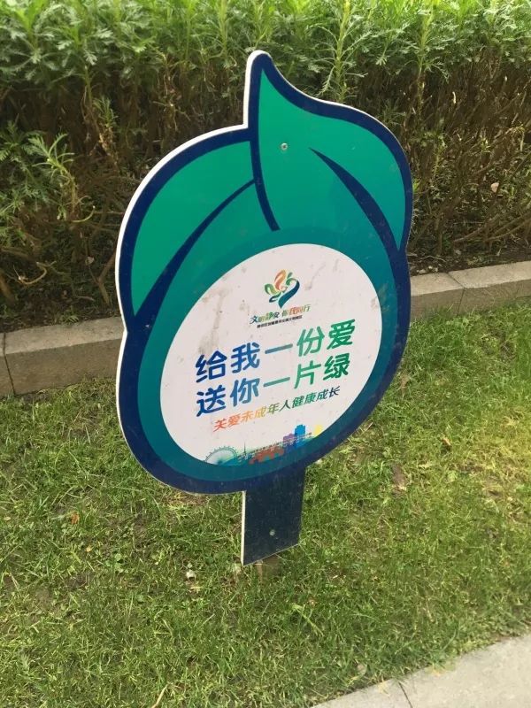 为了防止人们践踏草坪,物业公司放了宣传牌,就是内容