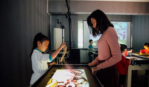 家长热衷培养孩子学习沙画 学费不贵还能发挥想象力