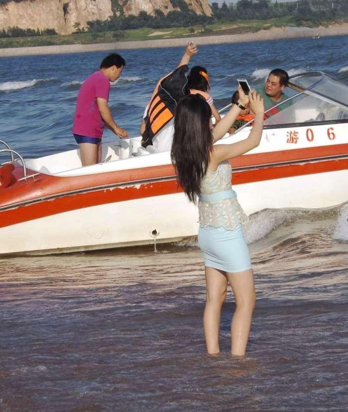 街拍小姐姐海边脱鞋, 弯腰时展现出包臀裙的巧