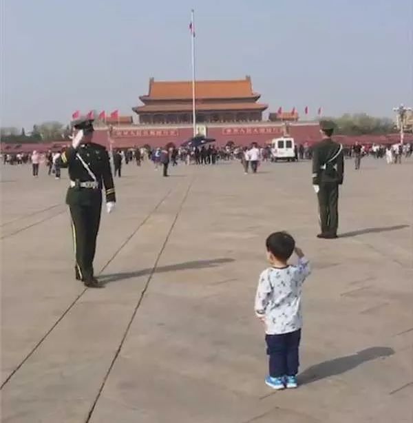 执勤武警看到小朋友的敬礼,也立即给小朋友回了一个军礼.