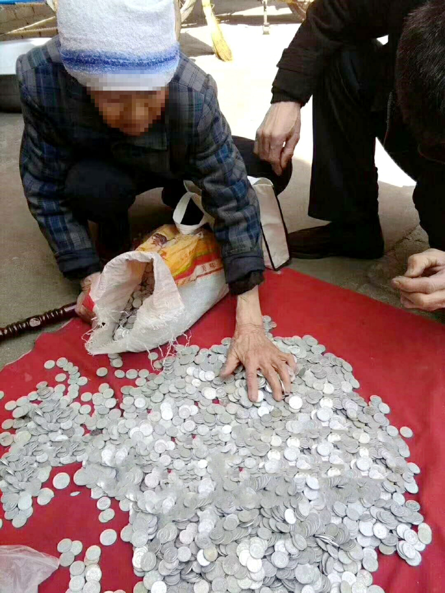 老人扛一大袋重达15斤的硬币去换钱,摊主却说