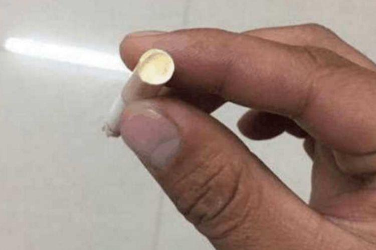 男子准备抽烟,发现烟滤嘴有异样,用指甲抠开后